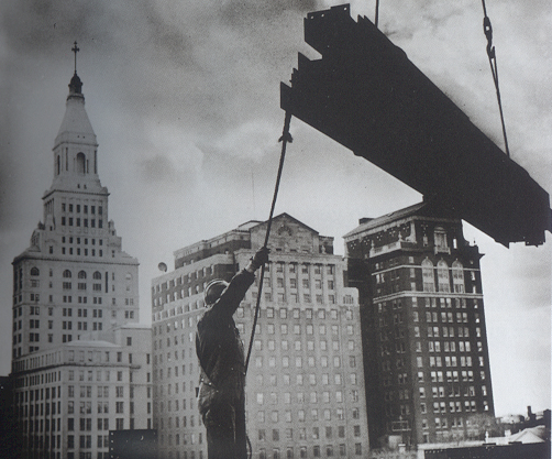 Hartford's skyline changed in 1960 when the Traveler's Insurance Company built 
            its new high-rise headquarters on Constitution Plaza. This shot is 
            taken from the top of the construction looking south towards 750 Main 
            Street (partially obscured by beam). The old Traveler's Tower is at 
            the left.