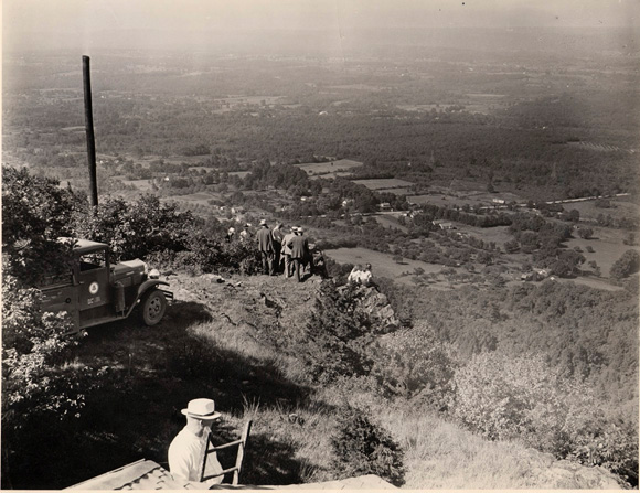 F.M. Doolittle on ladder overlooking valley below